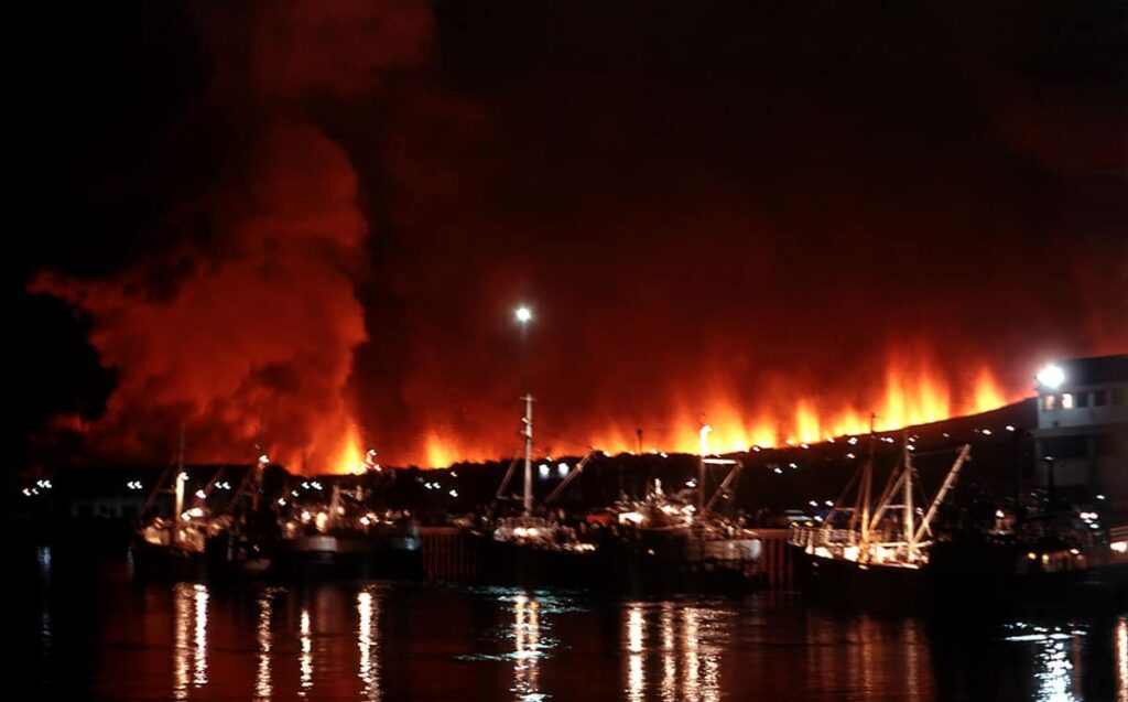Glowing lava lights up the night sky above Vestmannaeyjar harbour.